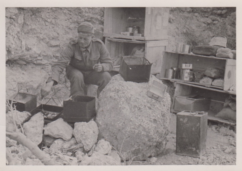 Polowe stanowisko kuchni pod Tobrukiem. Na zaimprowizowanych półkach wykonanych z drewnianych skrzyń leżą kartony z racjami żywnościowymi, konserwy mięsne, pieczywo oraz brytyjskie menażki, 1941 r. (MWB/D/1221)