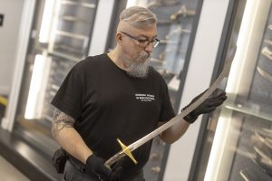 Mężczyzna trzyma w rękach szablę w stylu memeluckim