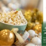 Na banerze miska popcornu w otoczeniu ozdób świątecznych