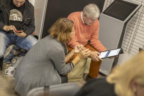 Uczestnik warsztatów oraz prowadząca pochyleni nad tabletem.